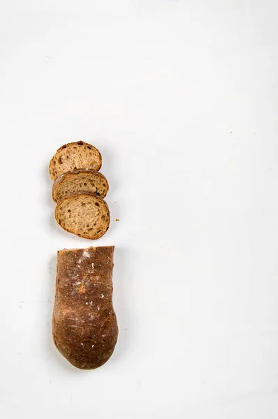 Gesneden in plakjes van een brood gemaakt van roggemeel ligt op een witte achtergrond. — Stockfoto