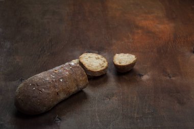 Kabuklu buğday ekmeği. Sıcak ahşap parlak arka planda.