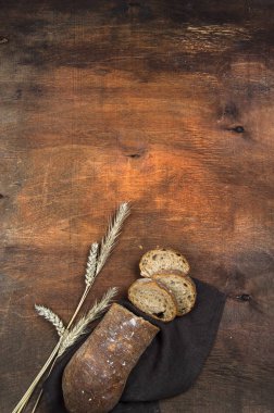 Kabuklu buğday ekmeği. Sıcak ahşap parlak arka planda.