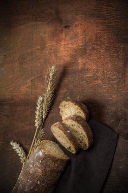 Kabuklu buğday ekmeği. Sıcak ahşap parlak arka planda.