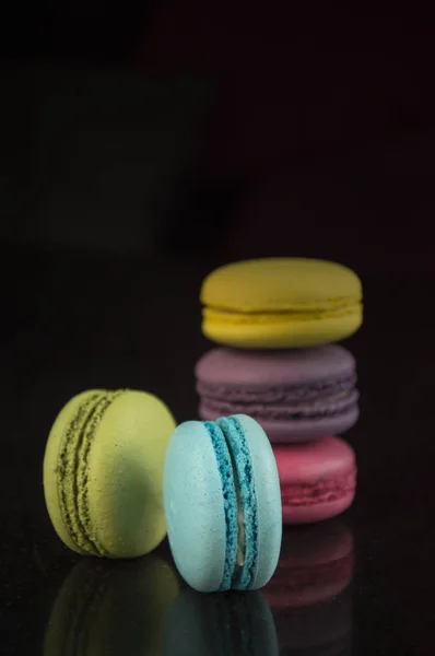 Pasteles de almendras multicolores sobre un fondo oscuro —  Fotos de Stock