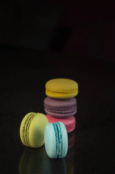 Pasteles de almendras multicolores sobre un fondo oscuro —  Fotos de Stock