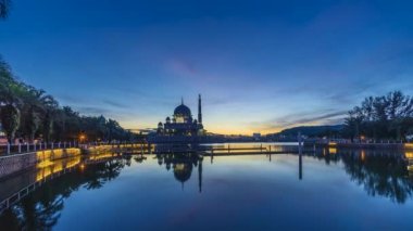 Putra Camii 'nde, Putrajaya, Malezya' daki suda yansıyan bir gölün yanında güzel ve dramatik bir gündoğumu hızlandırılmış zaman..