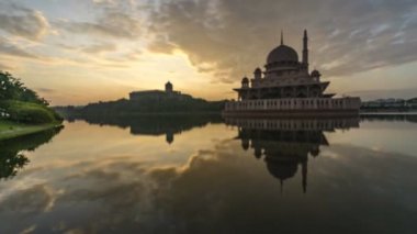 Putra Camii 'nde, Putrajaya, Malezya' daki suda yansıyan bir gölün yanında güzel ve dramatik bir gündoğumu hızlandırılmış zaman..