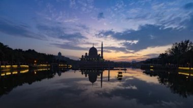 Putra Camii 'nde, Putrajaya, Malezya' daki suda yansıyan bir gölün yanında güzel ve dramatik bir gündoğumu hızlandırılmış zaman..