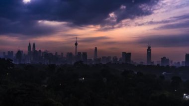 Kuala Lumpur şehrinin Bukit Tunku 'dan güzel gündoğumunun zaman aşımına uğraması. Arka plan olarak siluet gökdelen binası ile.