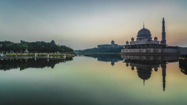 Putra Camii 'nde, Putrajaya, Malezya' daki suda yansıyan bir gölün yanında güzel ve dramatik bir gündoğumu hızlandırılmış zaman..