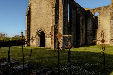 Eski bir kilisenin kalıntıları. Kutsal topraklarda birkaç ortaçağ taş mezarı var. Ön planda süslü demirden haçlar var..