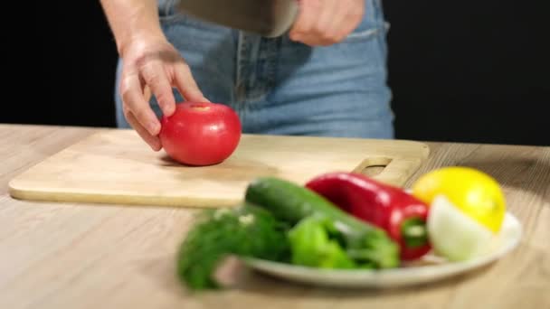Una giovane donna sta cucinando gazpacho crudo. Una giovane donna taglia un pomodoro maturo . Video Stock