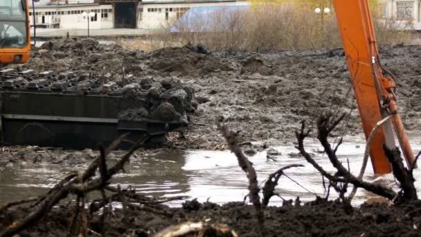 Excavadora con un cubo ancho limpia y profundiza el lecho del río — Vídeos de Stock