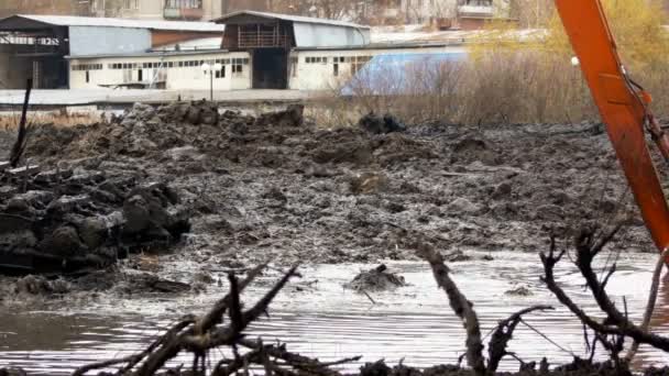 Excavadora con un cubo ancho limpia y profundiza el lecho del río — Vídeo de stock