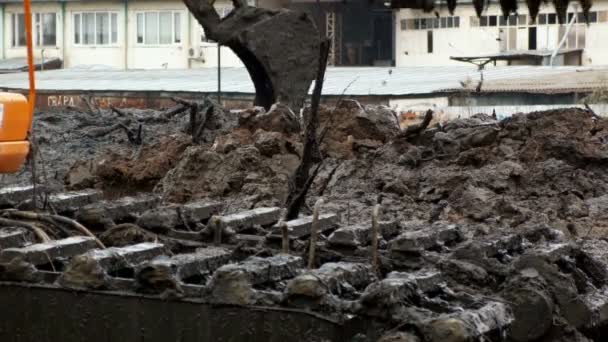 Un cubo de excavadora amplia cae tierra desde el fondo del río. Limpieza y profundización del canal . — Vídeo de stock