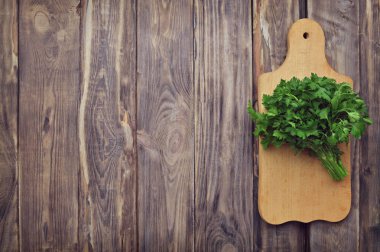 Bir kesme tahtası üzerinde taze yeşillik. Baharatlar, çeşniler. Sağlıklı beslenme kavramı. Maydanoz, ahşap arka plan üzerinde. Gıda arka plan. Yat-.