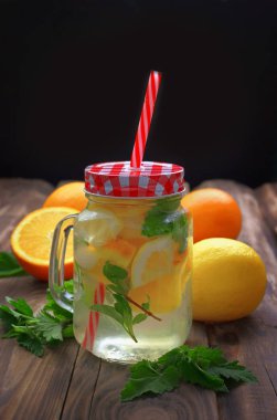 Limon ve nane yaprağı ile soğuk su. Kireç dilim ve buz küpleri ile taze limonata. Alkolsüz içecek ahşap tahta üzerinde. Tablo ayarı kırsal tarzda