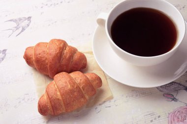 Bir fincan çay / kahve ve taze kruvasanlar. yakın çekim. Ara. Sabah. Kahvaltı, modern bir kadın. Modern yaşam.