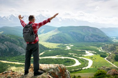 İnsan kolları gün doğumunda dağlarda uzanıyor özgürlüğün ve yaşamın tadını çıkarıyor. Yürüyüşçü.