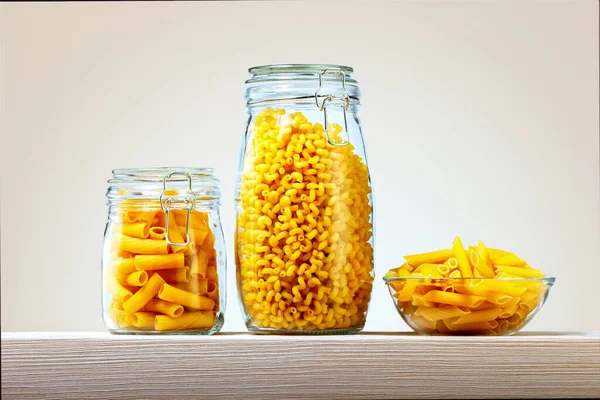 Close-Up Of Raw Pastas In Jars And Bowl On A Shelf.