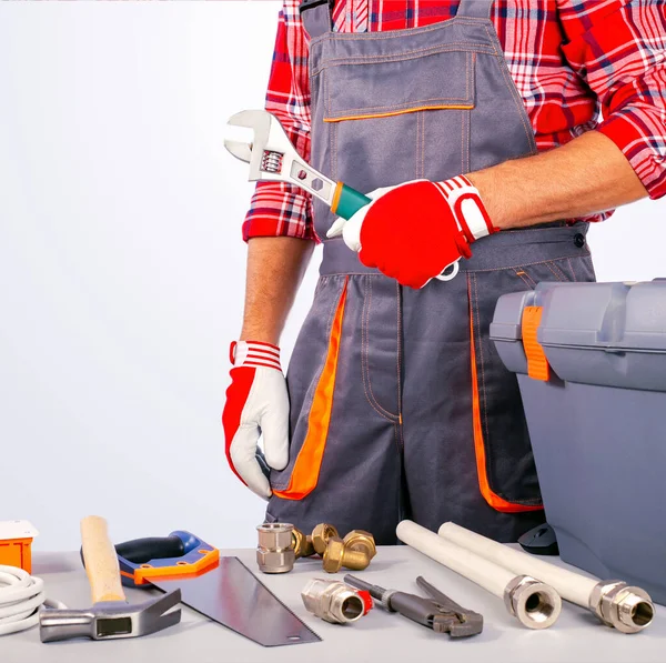 Bouwer Klusjesman Met Verstelbare Moersleutel Gereedschapskist Instrumenten Tafel — Stockfoto