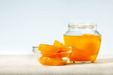 Tabakta konserve şeftali konservesi ve kavanoz var. Boşluğu kopyala.