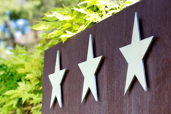 Metallic hotel sign board with three star. Quality service, buyer choice.