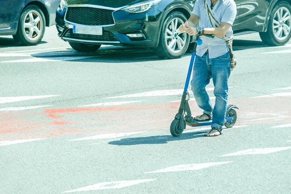 若い男が路上で電動スクーターを運転しています エコ代替都市交通 — ストック写真