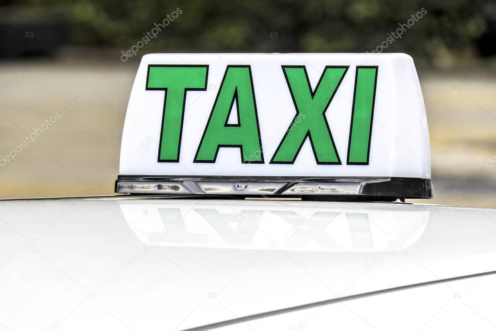 Close up of an taxi sign and its reflection