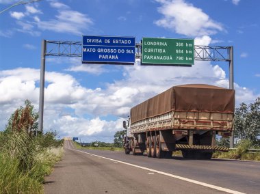 Mato Grosso Sul, Brezilya, 9 Mart 2006 yap. Kamyon yolda mesafeler Curitiba, Londrina ve Paranagua şehirlerine kilometre cinsinden belirten işaretler ile Birleşik Mato Grosso ve Parana, sınırı geçerse.