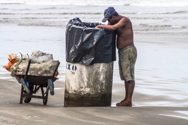 Sao Paulo, Brezilya, 04 Aralık 2009. Stela Maris Beach Peruibe, Güney Sahili yani Paulo deki Çöp Kutusu'ndaki geri dönüşüm için alüminyum kutular adam arar.