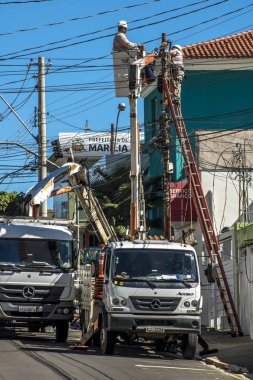 Marilia, Sao Paulo, Brezilya, Mayıs 26, 2019. İşçiler, Mrilia 'nın merkezindeki bir sokakta elektrik şebekesi alışverişi ve bakım bozdurma,