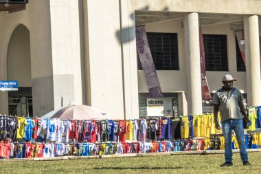 Sao Paulo, Brezilya, 12 Temmuz 2019. Farklı futbol takımlarının t-shirt Charles Miller Meydanı'nda bir sokak satıcısı tarafından, Paulo Machado de Carvalho Belediye Stadyumu önünde, Pacaembu Stadyumu olarak bilinen, Sao Paulo batısında satılmaktadır
