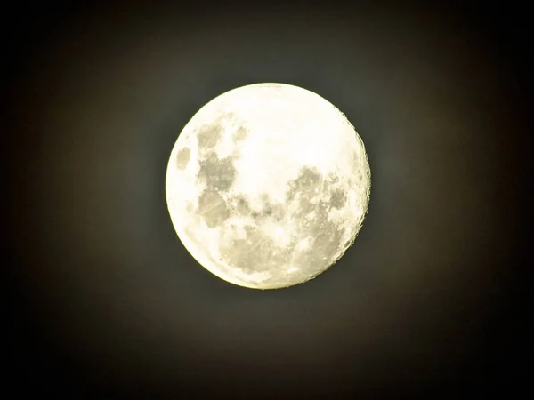 Moon in the middle of its way on the clear sky.