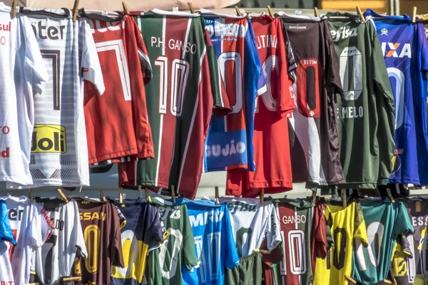 Sao Paulo, Brezilya, 12 Temmuz 2019. Farklı futbol takımlarının t-shirt Charles Miller Meydanı'nda bir sokak satıcısı tarafından, Paulo Machado de Carvalho Belediye Stadyumu önünde, Pacaembu Stadyumu olarak bilinen, Sao Paulo batısında satılmaktadır