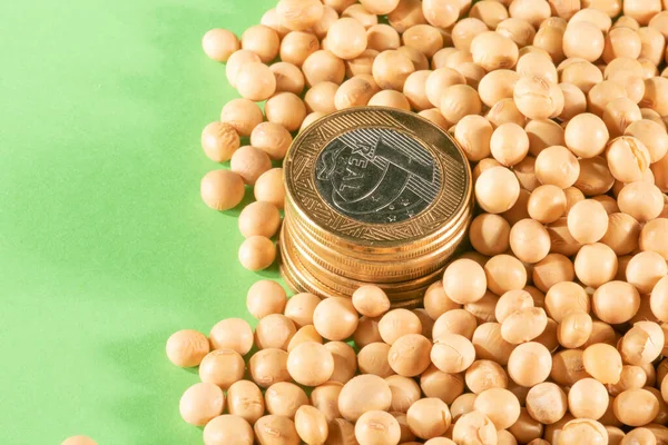 Soybeans and brazilian Real coins on a green background in Brazil