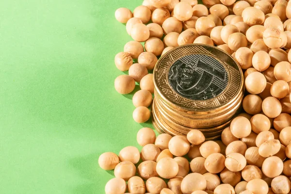 Soybeans and brazilian Real coins on a green background in Brazil