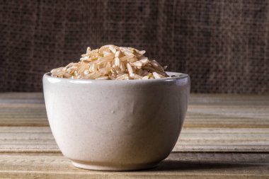 Brezilya 'da ahşap masada izole edilmiş cam kase üzerinde tamamlayıcı pirinç.