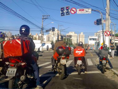 Sao Paulo, Brezilya, 16 Mayıs 2020. ifood işçisi ve diğer motosiklet teslimat şirketleri Sao Paulo şehrindeki müşterilere yiyecek ve ürün dağıtıyorlar..