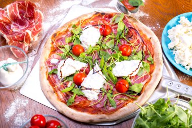 lezzetli İtalyan Pizza jambon, mozzarella, domates ve roka ile yakın çekim