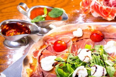 lezzetli İtalyan Pizza jambon, mozzarella, domates ve roka ile yakın çekim