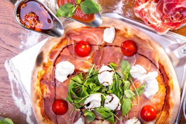lezzetli İtalyan Pizza jambon, mozzarella, domates ve roka ile yakın çekim