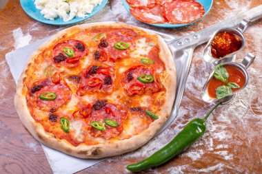 Lezzetli baharatlı pizza salam, mozzarella peyniri ve biber ile yakın çekim