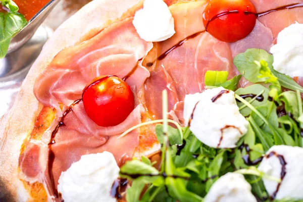 lezzetli İtalyan Pizza jambon, mozzarella, domates ve roka ile yakın çekim