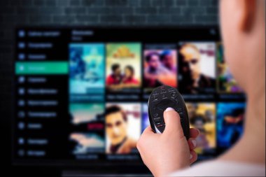 Multimedya yayın konsepti. Uzaktan kumandalı kadın eli. VoD içerik sağlayıcı kavramı