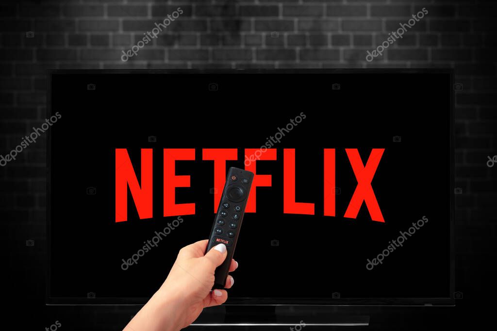 Close up of Nvidia Sheild TV Remote in Hand and TV Screen with Netflix Logo, Netflix is a well known global provider of streaming movies and TV series