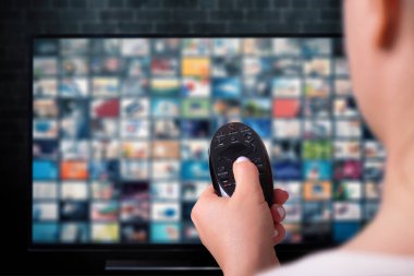 Multimedya yayın konsepti. Uzaktan kumandalı kadın eli. VoD içerik sağlayıcı kavramı