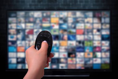 Multimedya yayın konsepti. Uzaktan kumandalı. Bir sürü resimli televizyon ekranı. VoD içerik sağlayıcı