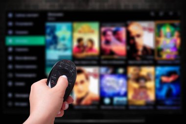 Multimedya yayın konsepti. Uzaktan kumandalı. Bir sürü resimli televizyon ekranı. VoD içerik sağlayıcı
