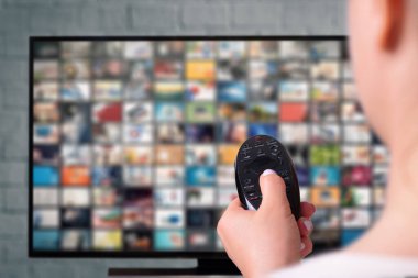 Multimedya yayın konsepti. Uzaktan kumandalı kadın eli. VoD içerik sağlayıcı kavramı