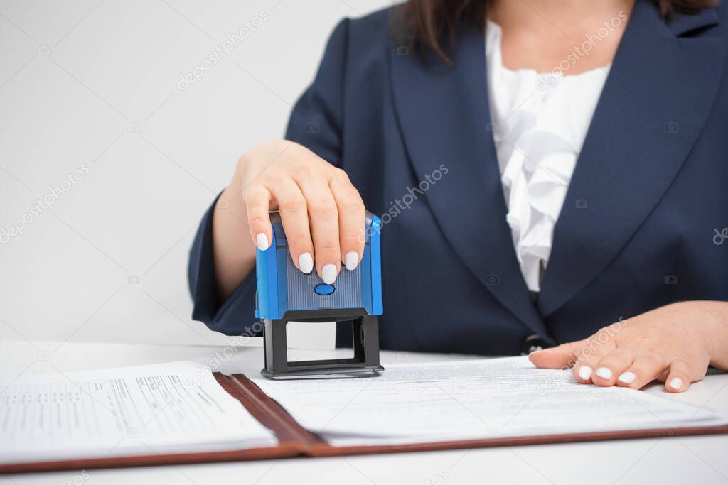 official notary clerk in a blue jacket Putting Stamp On Documents, Office concept