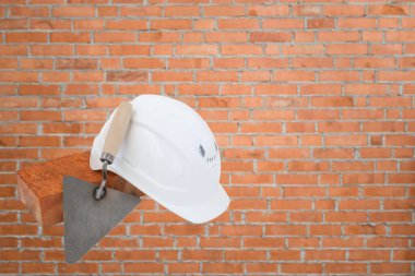 Tuğla, beyaz şapka ve tuğla duvar zemininde mala. İnşaat konsepti kopyalama alanı