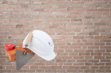 Tuğla, beyaz başlık, mezura. Duvarın arkasında. İnşaat konsepti kopyalama alanı